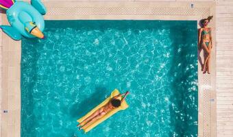 Friends in swimsuit who tan in the sunbed in a swimming pool photo