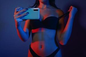 mujer en lencería tomar fotos con un teléfono inteligente