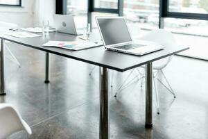 Modern office with graph sheets and laptop on a desk photo