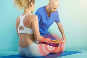 Girl performs exercises with a physiotherapist. Cyan background photo