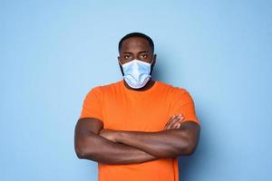 Man with face mask has a lot of questions and doubts about covid 19. cyan background photo