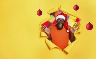 afro hombre con sombrero es contento porque es Navidad. amarillo antecedentes foto