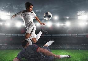 Close up of a football action scene with competing soccer players at the stadium during a night match photo