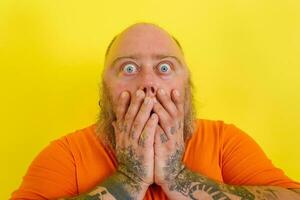 Man with beard and tattoos is worried about something photo