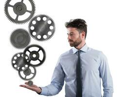 Businessman holds a gear system. Concept of business mechanism photo