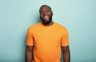 Joyful and happy guy over cyan background photo