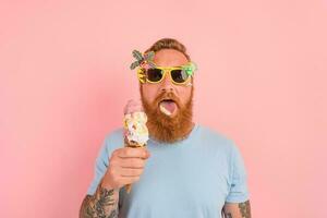 Hungry man with beard and tattoos eats a big icecream photo