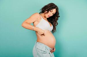 Pregnant amazed woman expecting a child caresses her belly photo