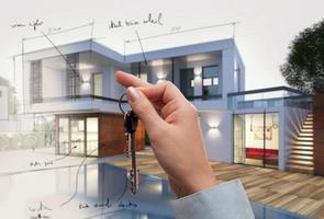 Real estate sale concept with key of a new house in project photo