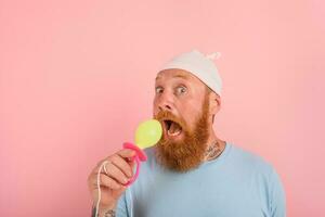 Man with beard and tattoos acts like a little newborn baby with pacifier in hand photo