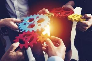 Business team connect pieces of gears. Teamwork, partnership and integration concept photo