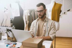 Seamstress works to new clothes ordered by internet client photo