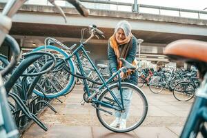 mayor mujer obtiene el bicicleta en un estacionamiento foto