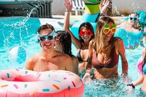 grupo de amigos en traje de baño disfrutar en un nadando piscina foto