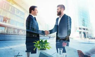 Handshaking business person in office. concept of teamwork and partnership. double exposure photo