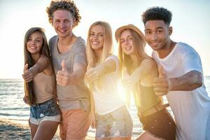 Group of friends having fun on the beach. Concept of summertime photo