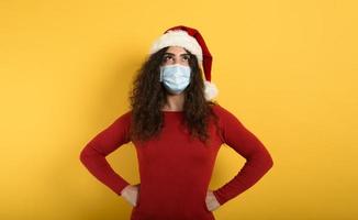 Woman with face mask is confused about something. yellow background photo