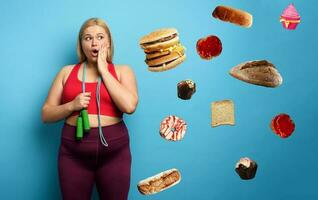 Fat girl does gym but she think always at food. cyan background photo