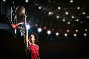 baloncesto jugador en rojo uniforme saltando alto a hacer un golpe remojar a el cesta foto