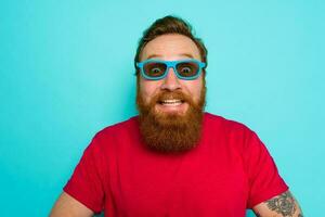 Man with beard and sunglasses is wondered and happy photo