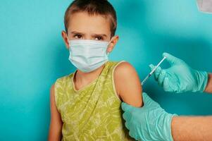 Doctor injects vaccine to a child against covid19 coronavirus photo