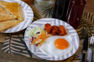 desayuno, frito huevos, frito embutido, vegetal ensalada y brindis en un marrón de madera mesa con café. foto