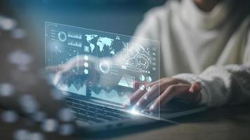 The programmer uses a laptop to analyze and developing at various information on a futuristic virtual interface screen. Algorithm. marketing and deep learning of artificial intelligence photo