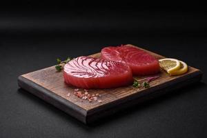 Two fresh slices of raw tuna fillet with spices and herbs photo