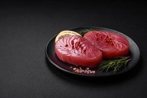 Two fresh slices of raw tuna fillet with spices and herbs photo