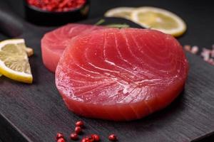 Two fresh slices of raw tuna fillet with spices and herbs photo