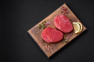 Two fresh slices of raw tuna fillet with spices and herbs photo