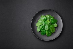 Fresh green spinach leaves on a black ceramic plate photo