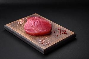 Two fresh slices of raw tuna fillet with spices and herbs photo