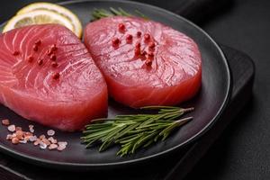 Two fresh slices of raw tuna fillet with spices and herbs photo