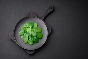 Fresh green spinach leaves on a black ceramic plate photo