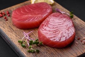 Two fresh slices of raw tuna fillet with spices and herbs photo