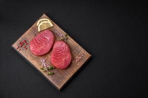 Two fresh slices of raw tuna fillet with spices and herbs photo