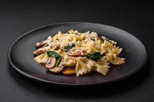 Delicious farfalle pasta with mushrooms, cheese and spinach with spices photo