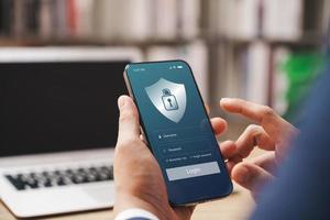Cybersecurity internet and networking concept. Close up of hand holding smartphone information security and encryption, secure access to user's personal information. photo