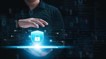 Cybersecurity concept, personal data protection and network security. Businessman holding key protecting business and financial data on tablet, secure internet access, security encryption. photo