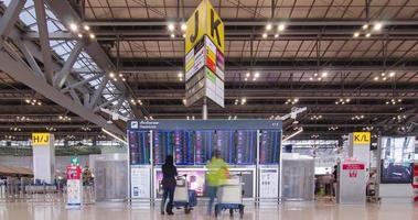 June 2,2022 Bangkok,Thailand  timelapse view inside departure terminal with many passenger while checking information check-in board. suvarnabhumi airport thailand reopening country video