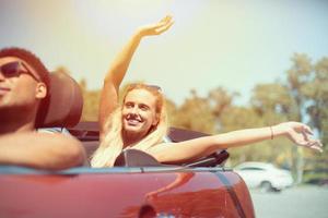 Young woman in cabriolet car departs for the summer holidays photo