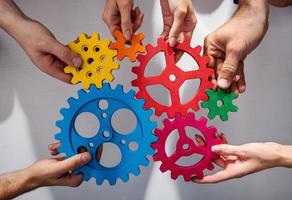 Business team connect pieces of gears. Teamwork, partnership and integration concept photo