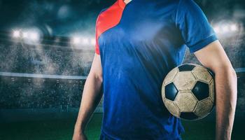 Soccer player ready to play with ball in his hands at the stadium photo