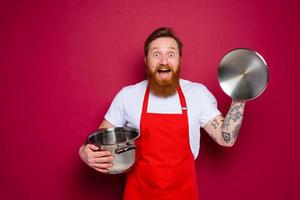 surprised chef with beard and red apron is ready to cook photo