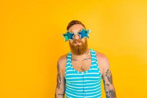 hombre con barba, tatuajes y traje de baño es Listo para el verano foto