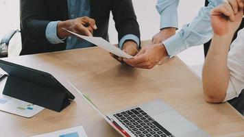 Financial analysts analyze business financial reports on a digital tablet planning investment project during a discussion at a meeting of corporate showing the results of their successful teamwork. video