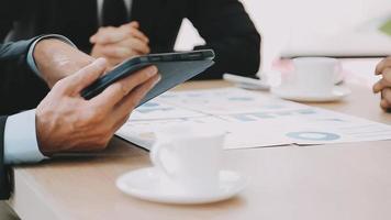 Financial analysts analyze business financial reports on a digital tablet planning investment project during a discussion at a meeting of corporate showing the results of their successful teamwork. video