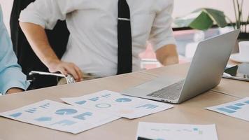 Financial analysts analyze business financial reports on a digital tablet planning investment project during a discussion at a meeting of corporate showing the results of their successful teamwork. video