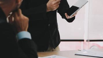 Financial analysts analyze business financial reports on a digital tablet planning investment project during a discussion at a meeting of corporate showing the results of their successful teamwork. video